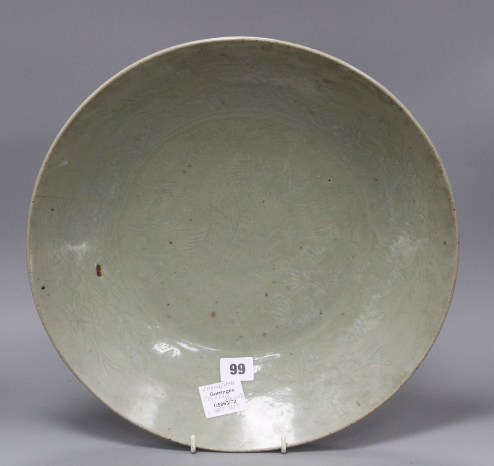 A Chinese Ming celadon dish, Zhangzhou kilns, c.1580-1620, incised with fish and water plants, diameter 38.5cm, height 8cm